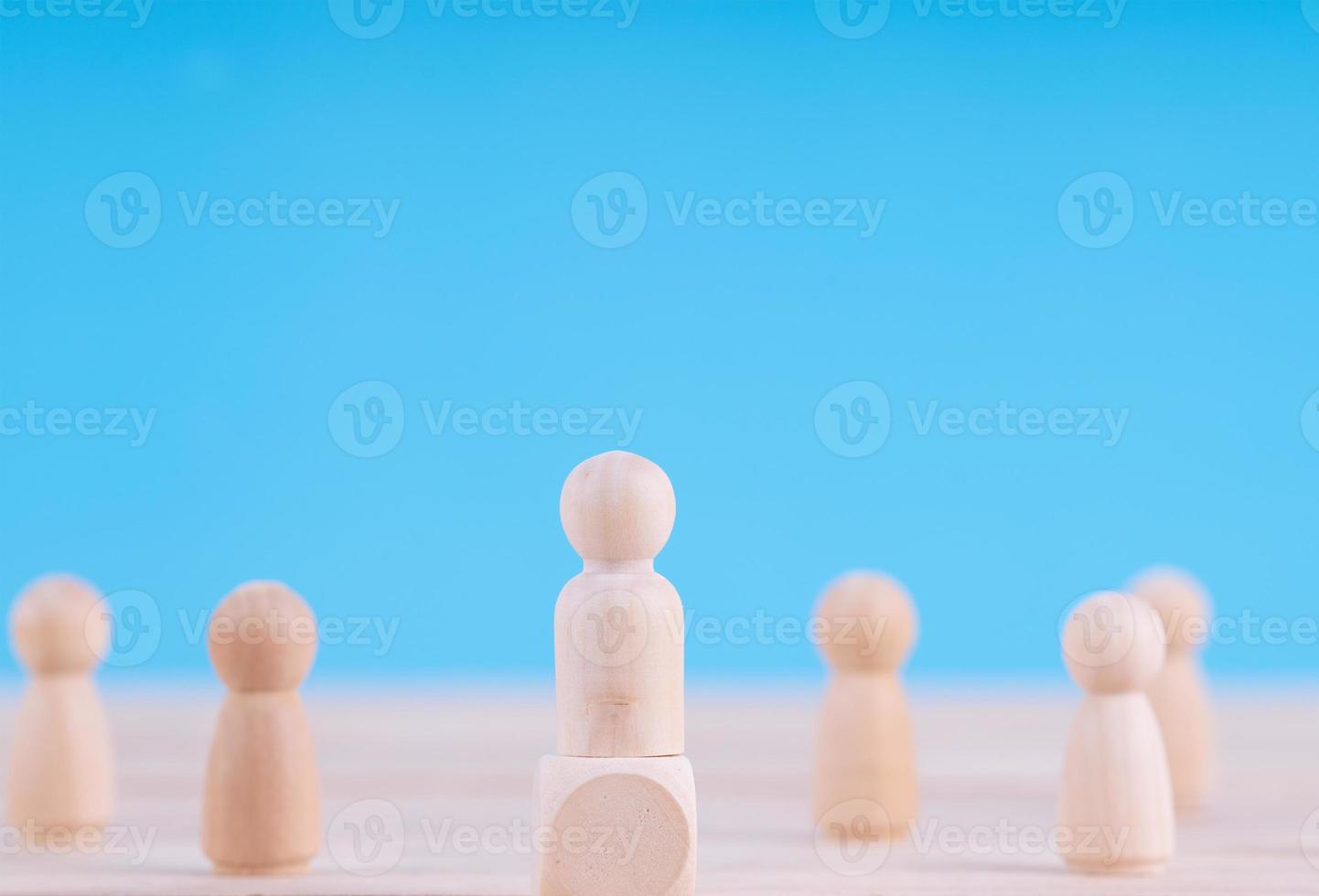 Wooden figures in photo of people.  Team and leader concept