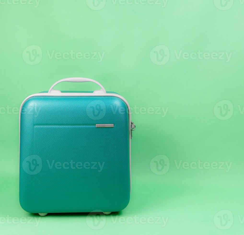 Equipaje verde para viajar sobre fondo verde foto