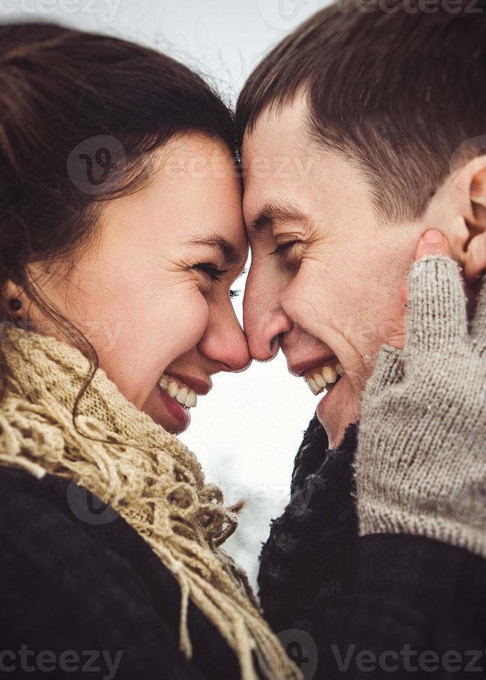 Guy and a girl in clothes and scarves on a walk in the snowy weather photo