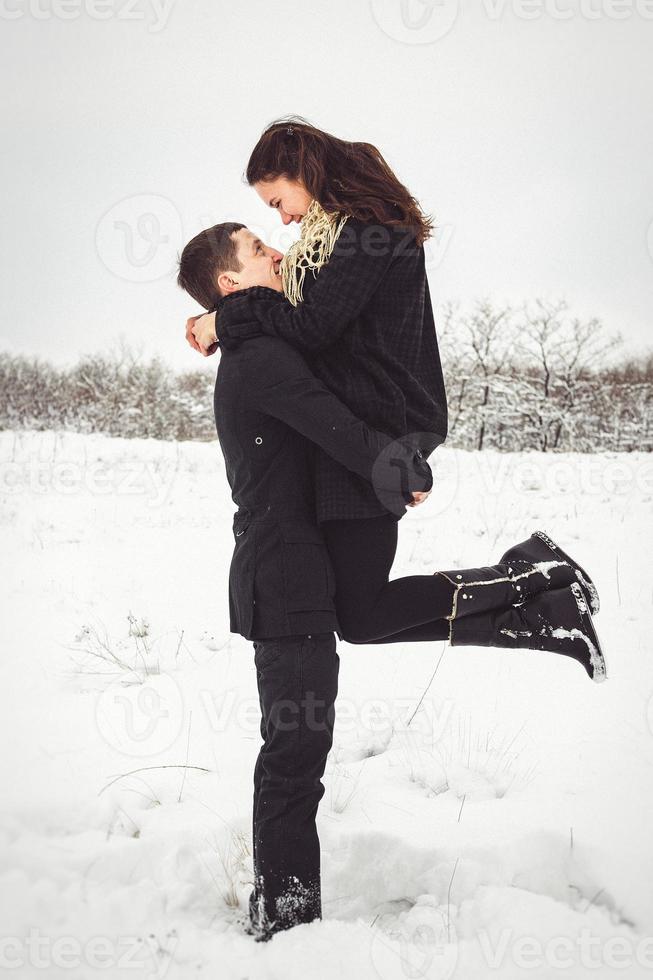 Guy and a girl in clothes and scarves on a walk in the snowy weather photo