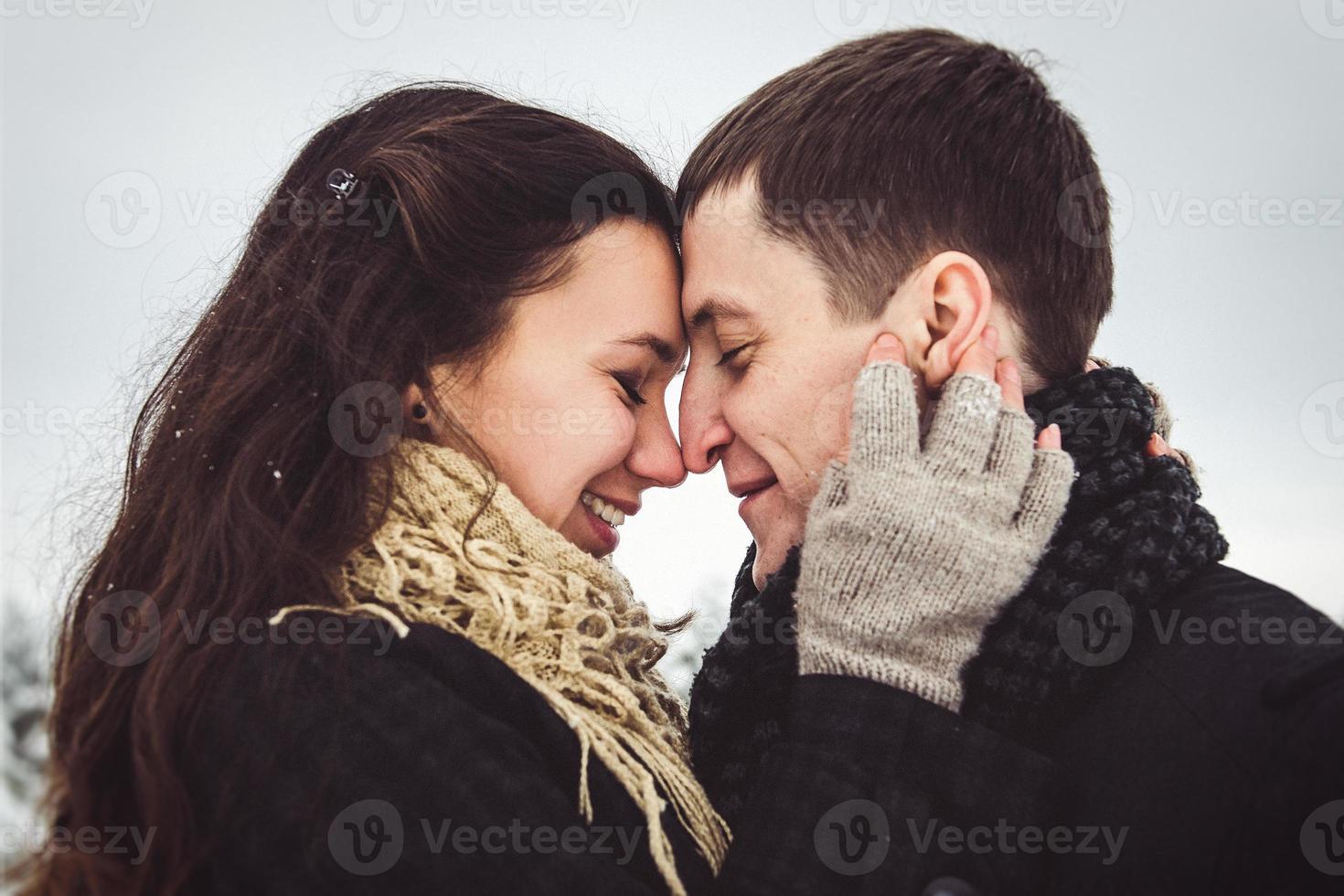 Guy and a girl in clothes and scarves on a walk in the snowy weather photo