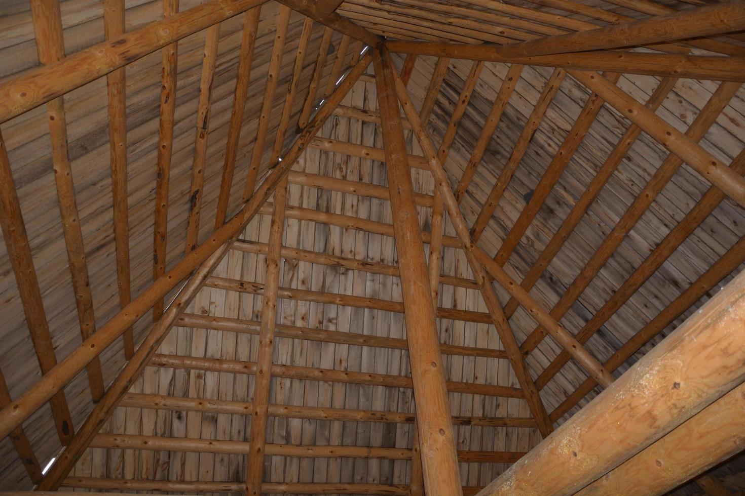 Beams made of logs under the dome of the roof photo