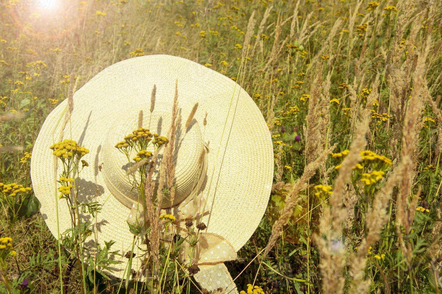 A straw hat in the rays of the sunset against a background photo