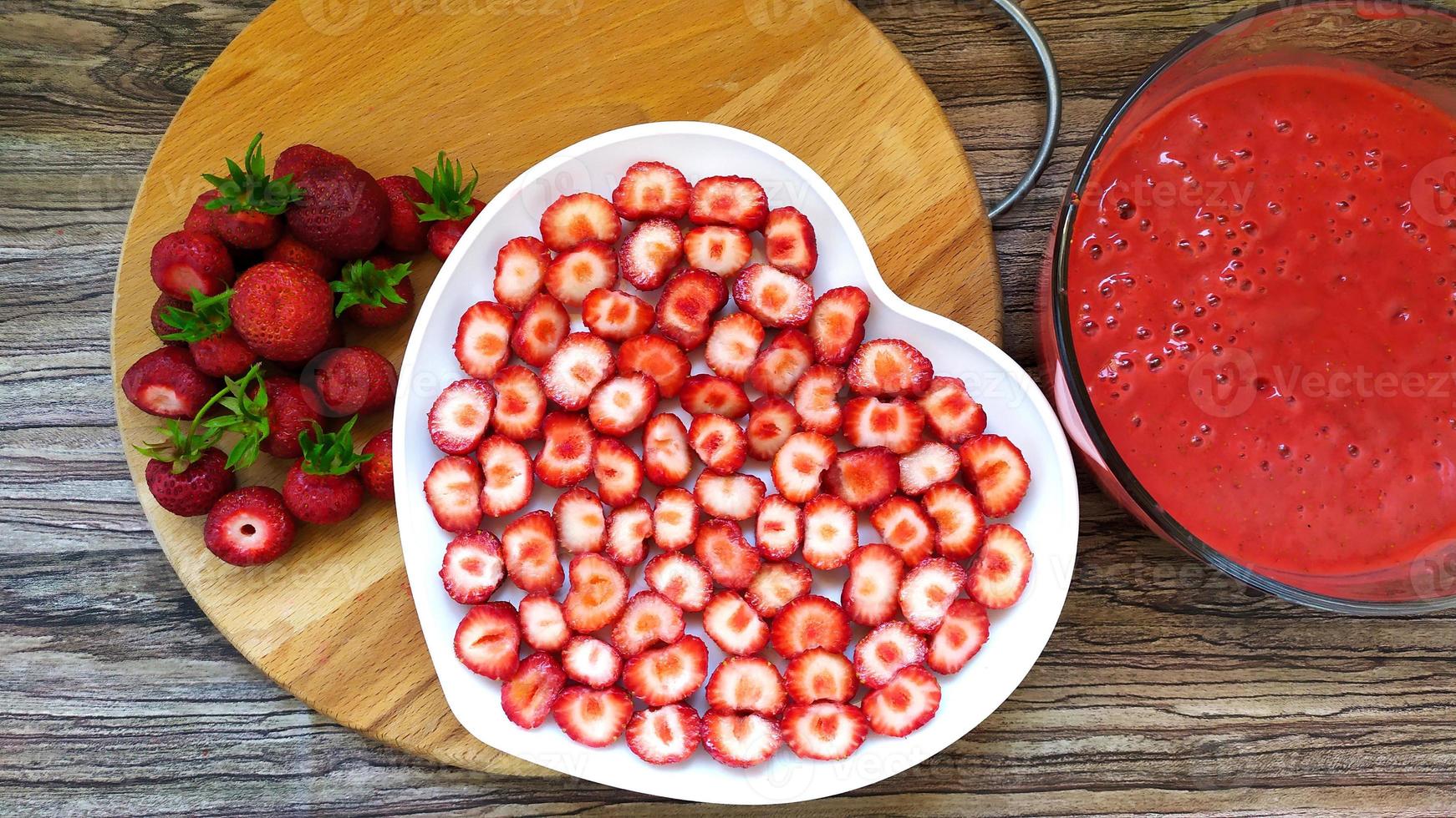 Rodajas de fresa en un plato blanco en forma de corazón foto