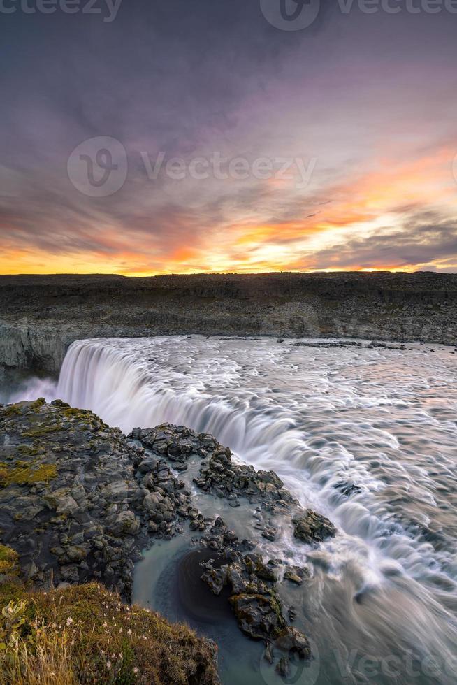 Cascada detifoss con puesta de sol en el fondo foto