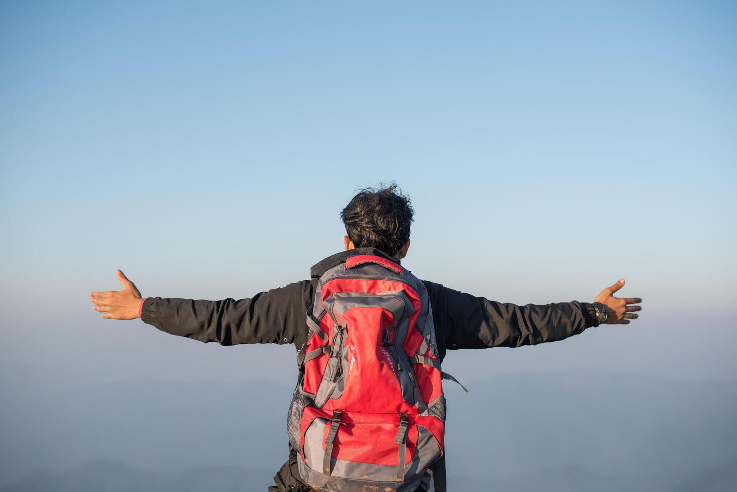 Hombre que viaja con mochila de senderismo en las montañas foto