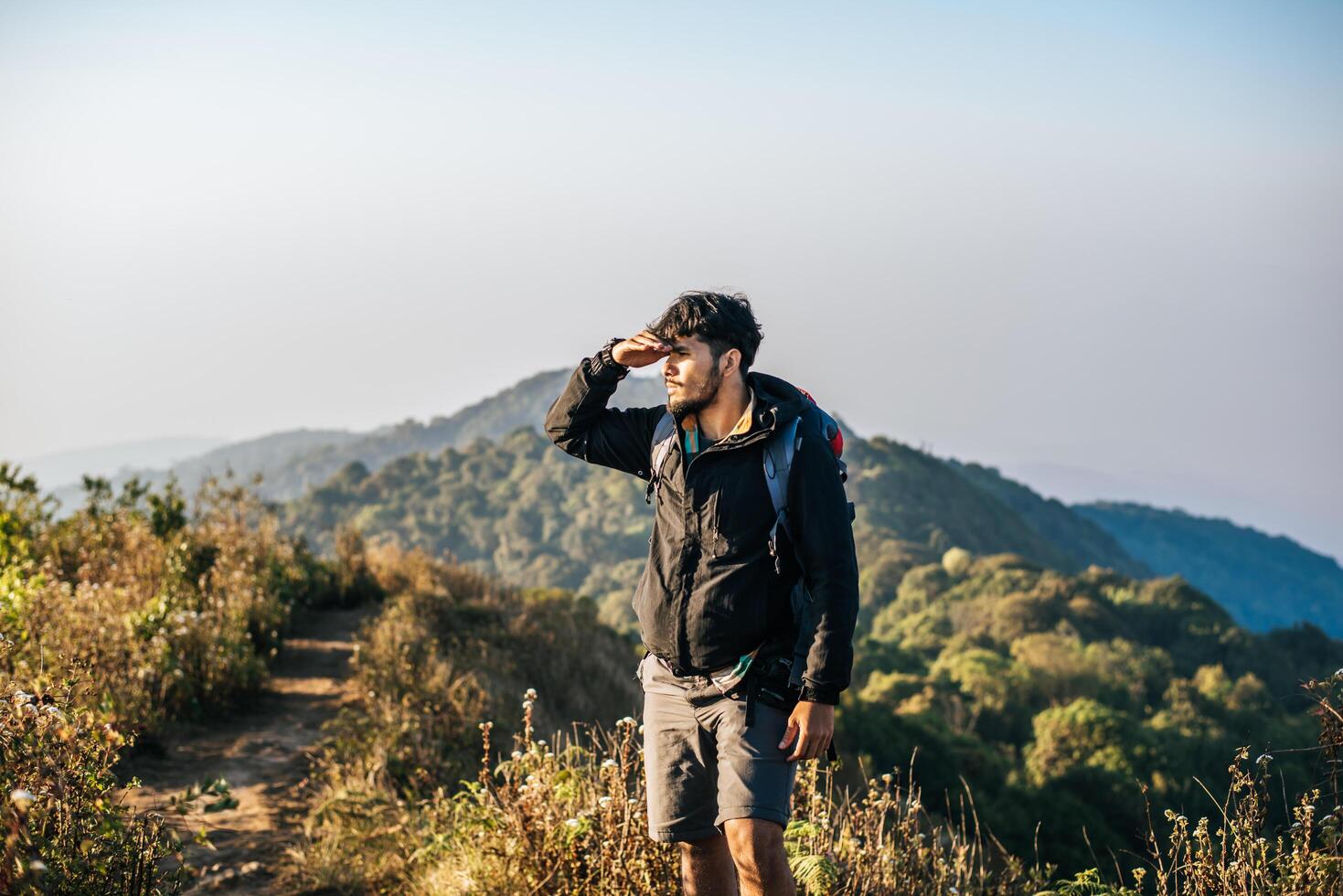 Hombre que viaja con mochila de senderismo en las montañas foto