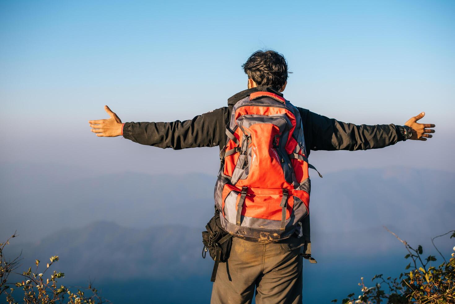 Hombre que viaja con mochila de senderismo en las montañas foto