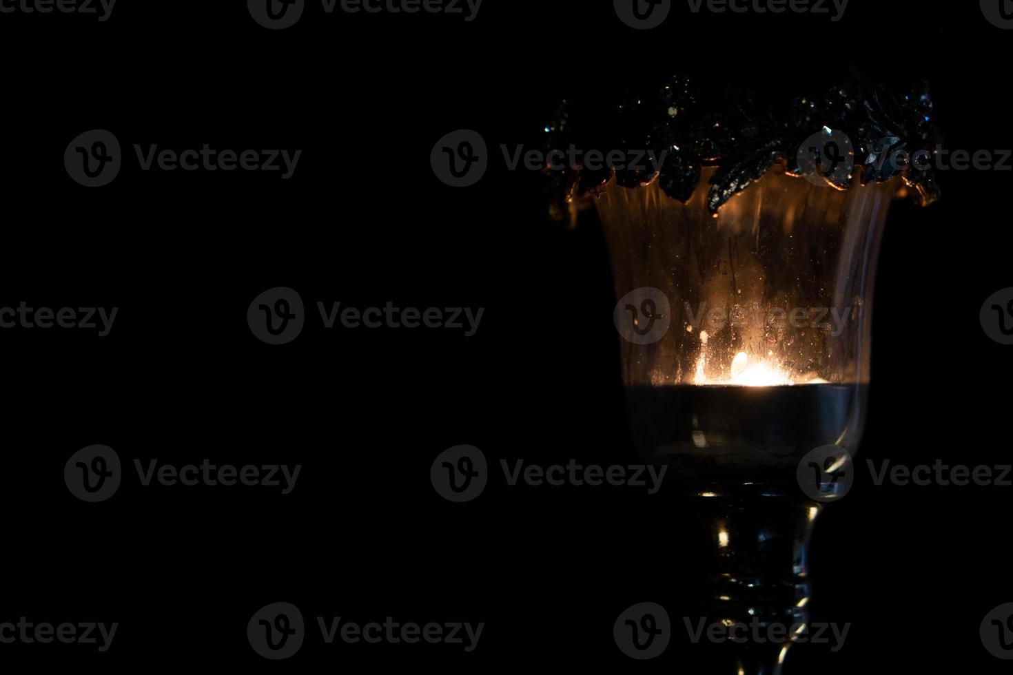 lámpara de vela encendida en la oscuridad foto