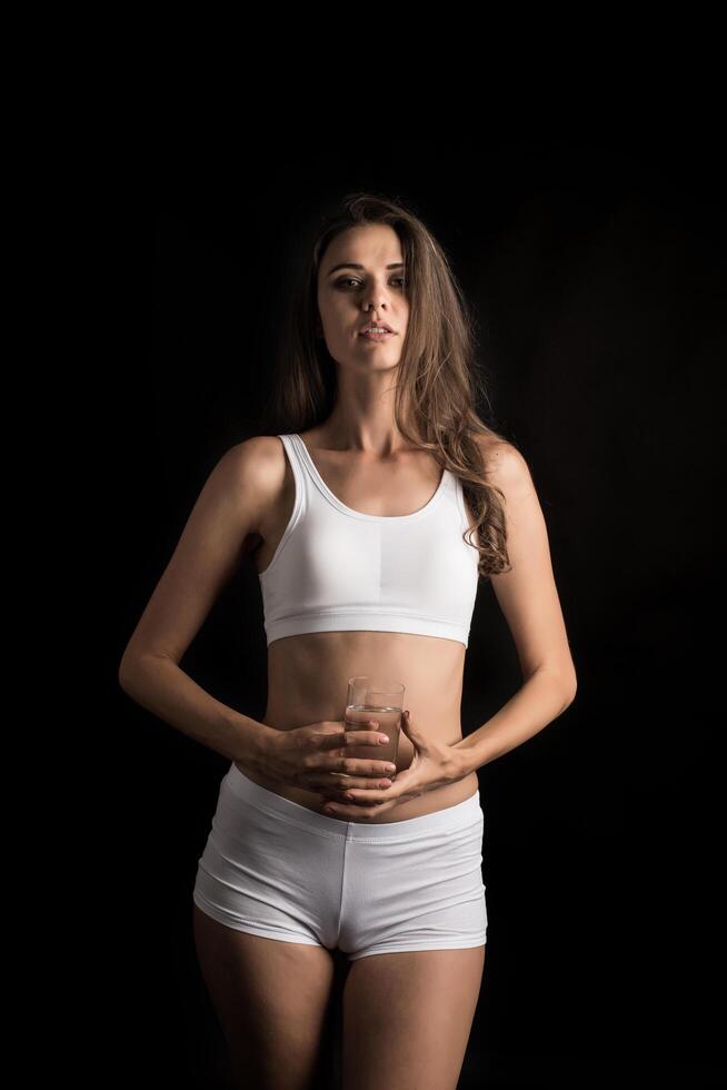 modelo de fitness femenino sosteniendo un vaso de agua foto