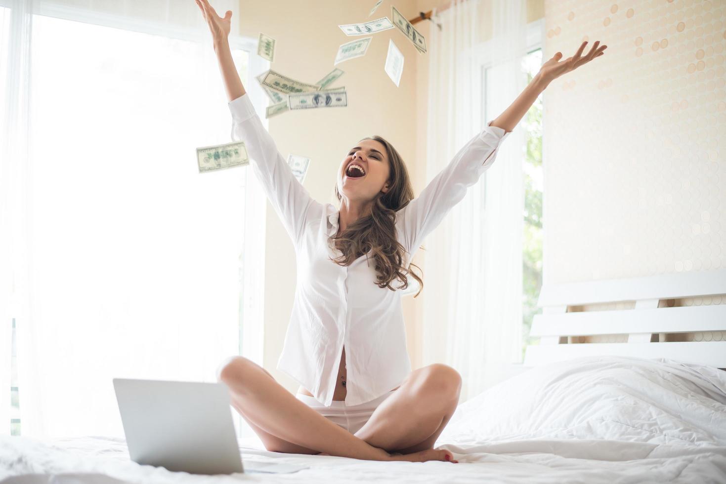Woman with dollar bank note on the bed photo