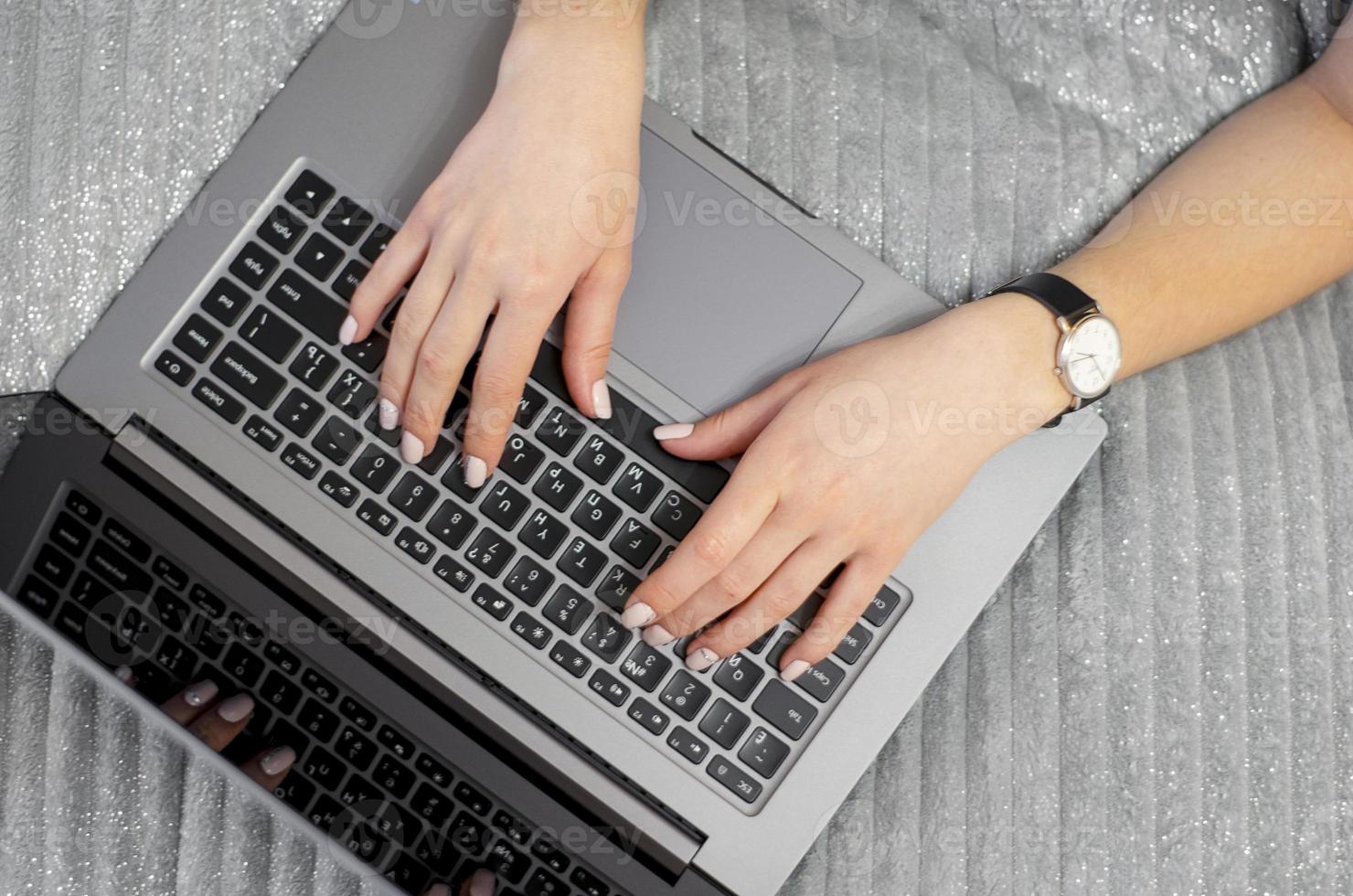 The girl is typing on the keyboard. View from above. photo