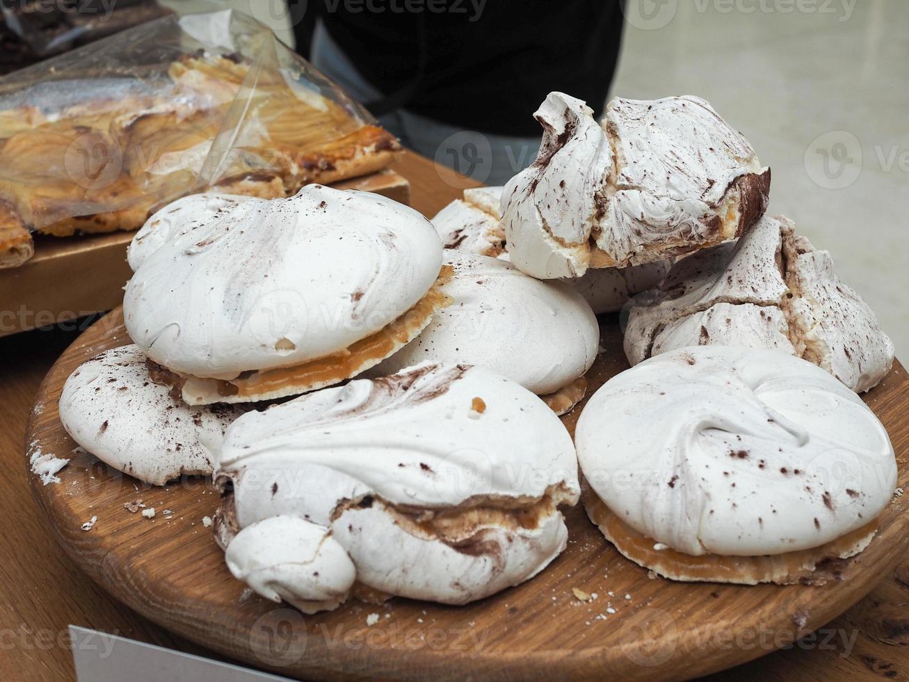 Dulces de merengue en placa de madera foto