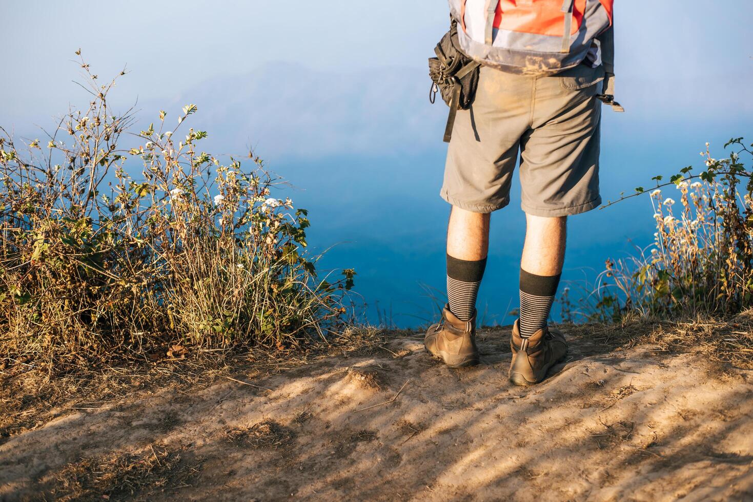 Hombre que viaja con mochila de senderismo en las montañas foto