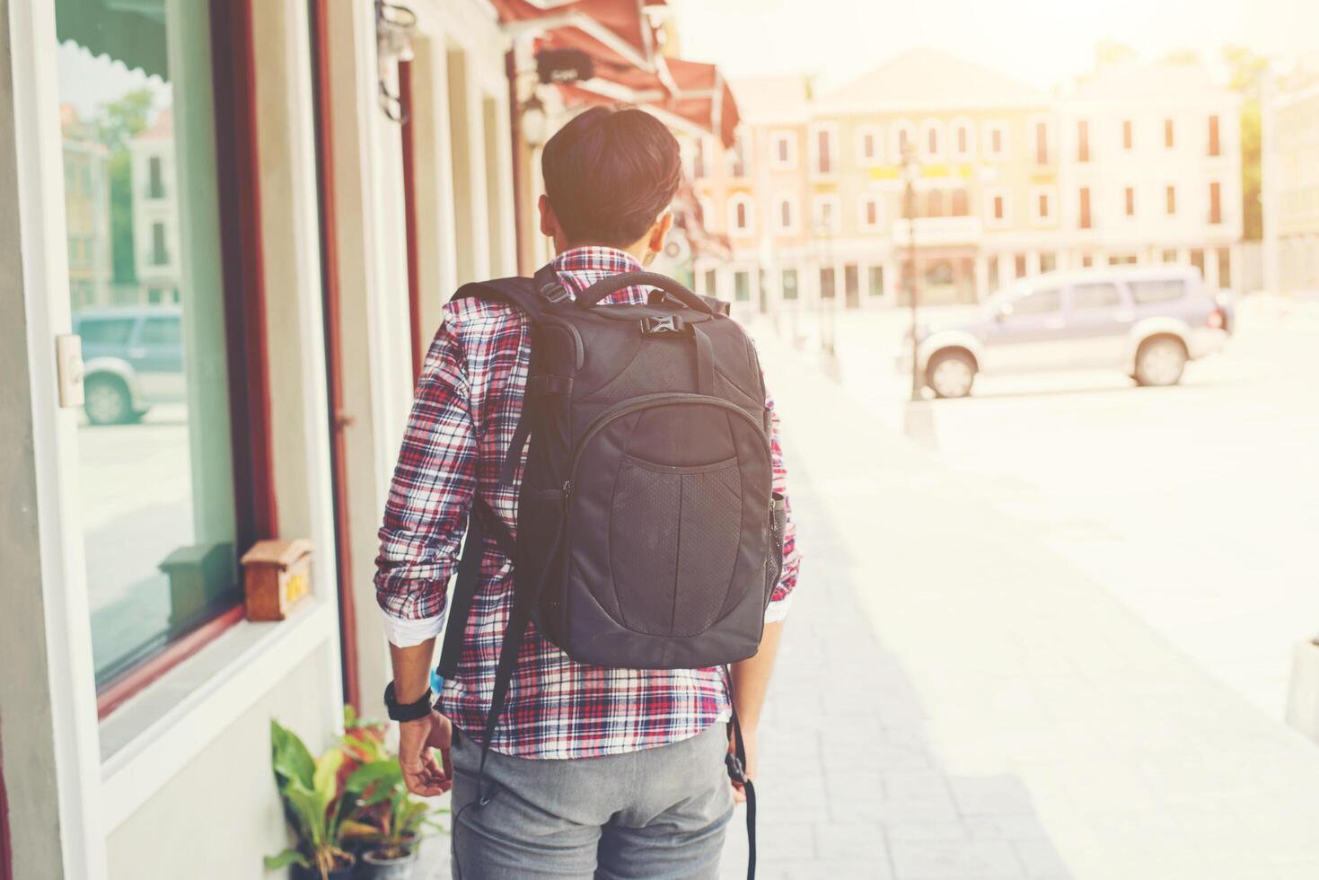 Parte trasera del joven viajero con mochila en unas vacaciones de aventura foto