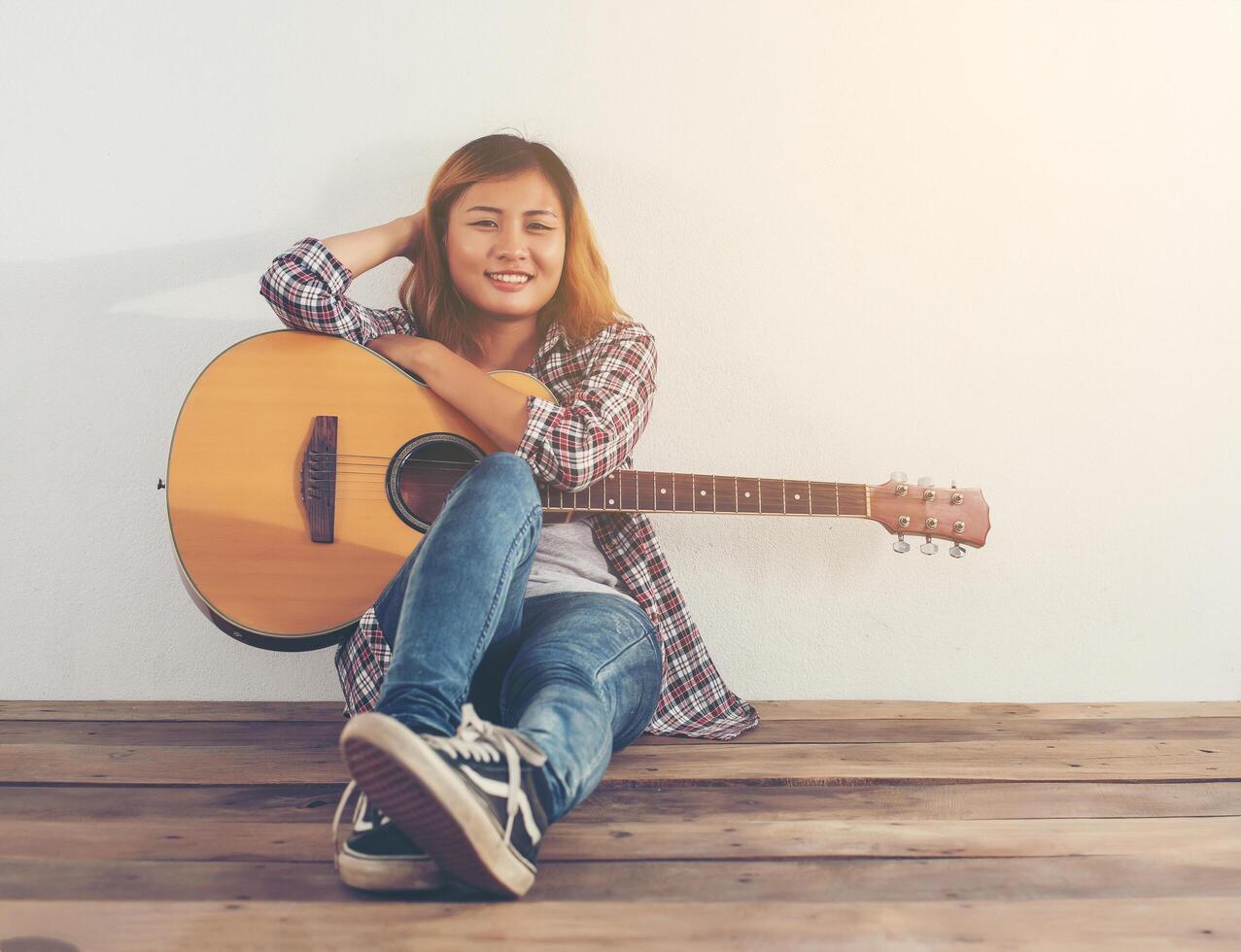 Retrato de estilo hipster mujer chillin con guitarra foto