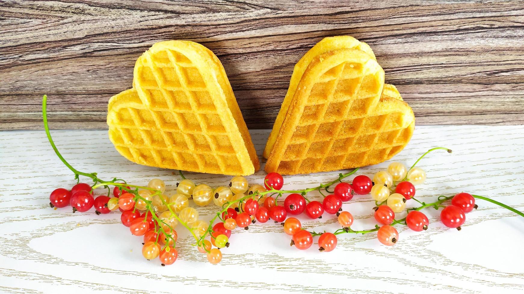 Cookies with hearts with currant berries on a wooden background photo