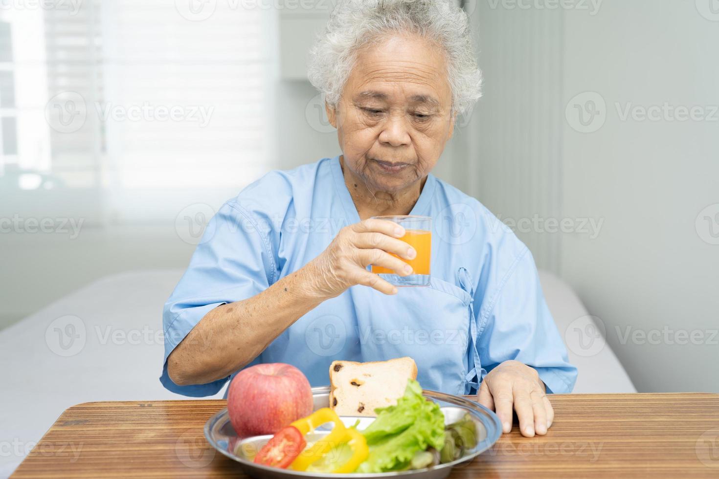 Paciente mujer mayor asiática desayunando foto