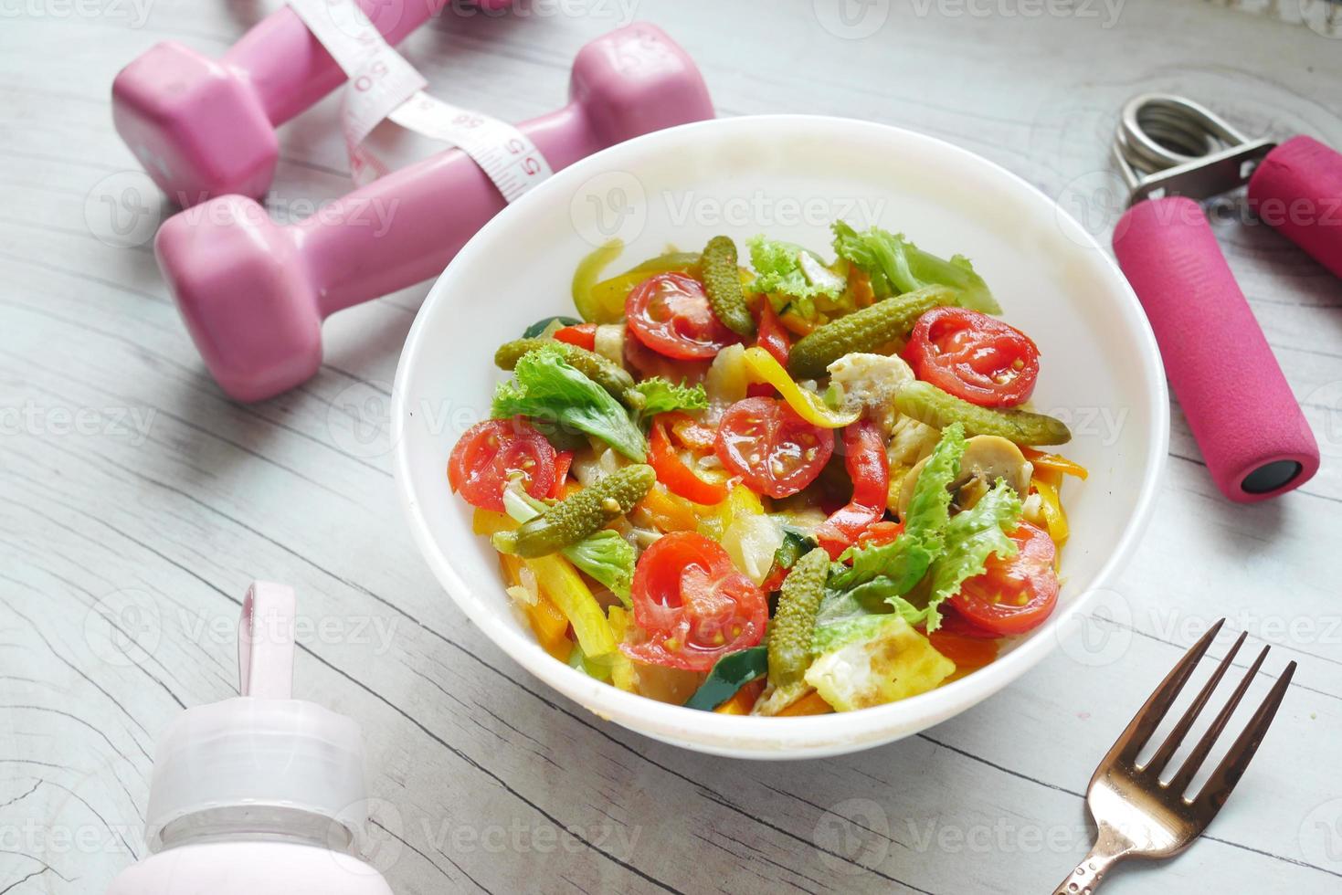 Fitness concept with dumbbell, fresh vegetable and measurement tape photo