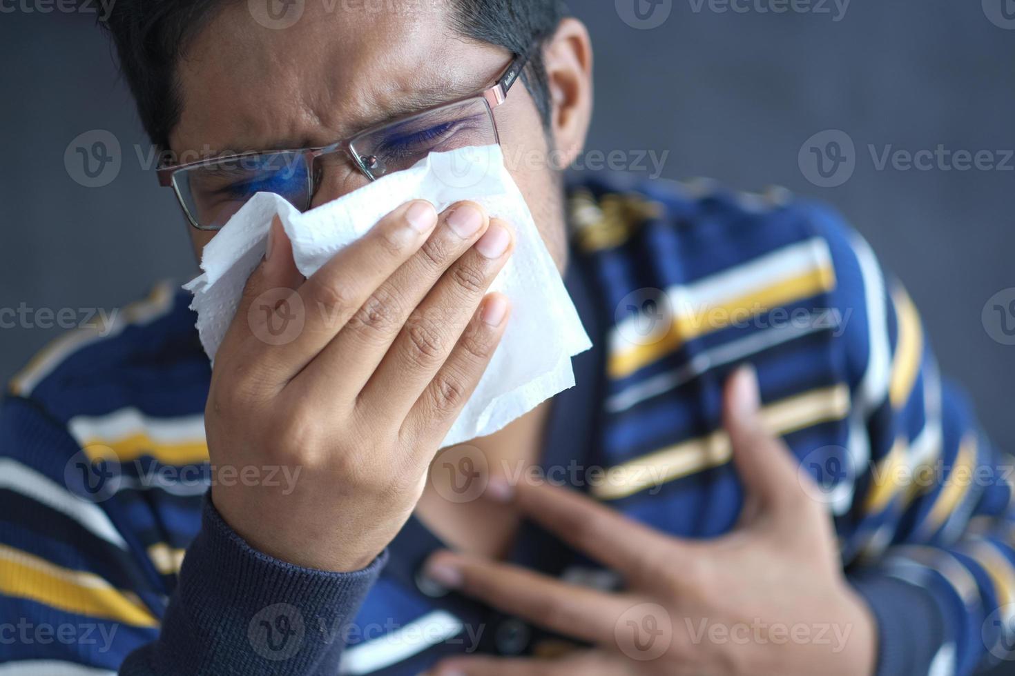 enfermo con gripe sonarse la nariz con una servilleta. foto