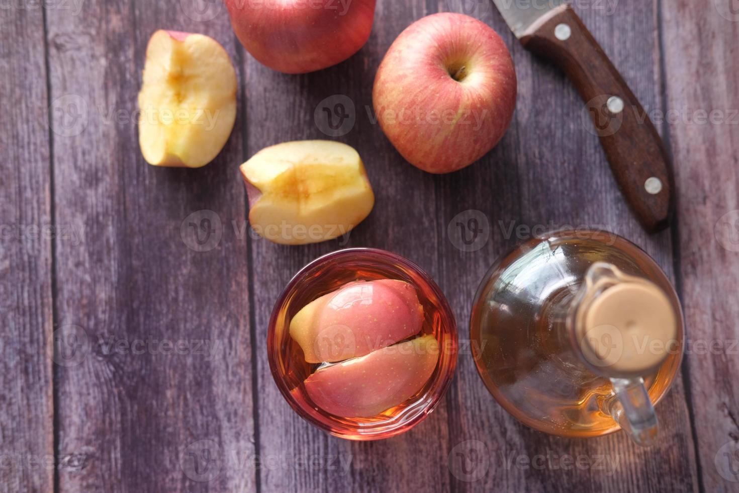 vinagre de manzana en vaso con manzana fresca en la mesa, vista superior foto