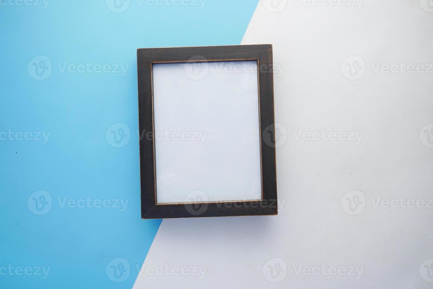 top view of empty frame on color background photo
