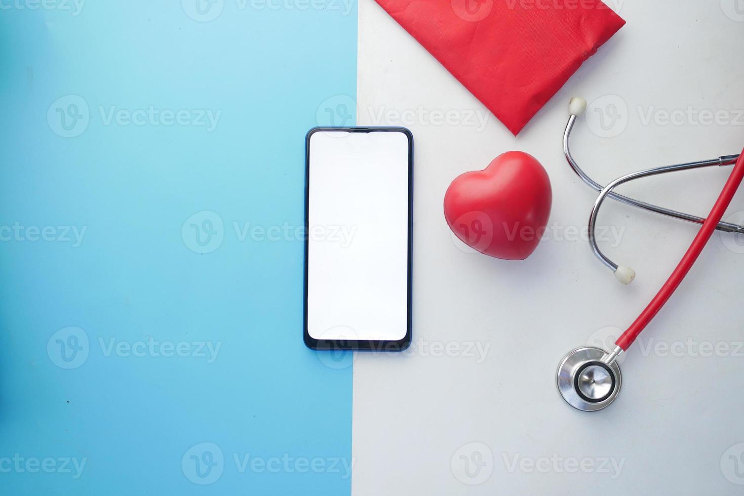 top view of smart phone with empty screen and stethoscope on table photo