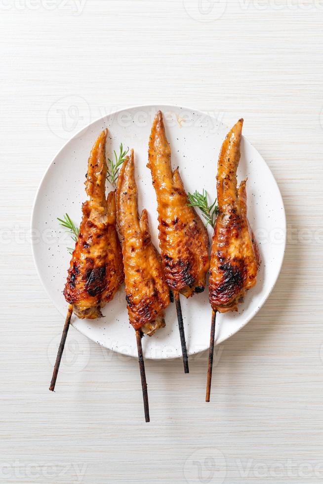 Grilled or barbecue chicken wings skewer on plate photo