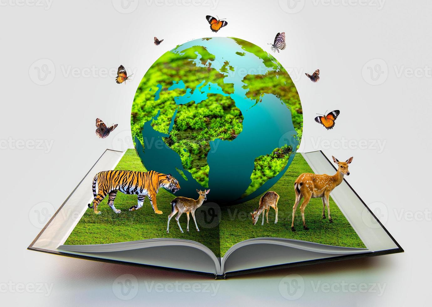 The globe is on the book and there are wild animals such as tigers photo