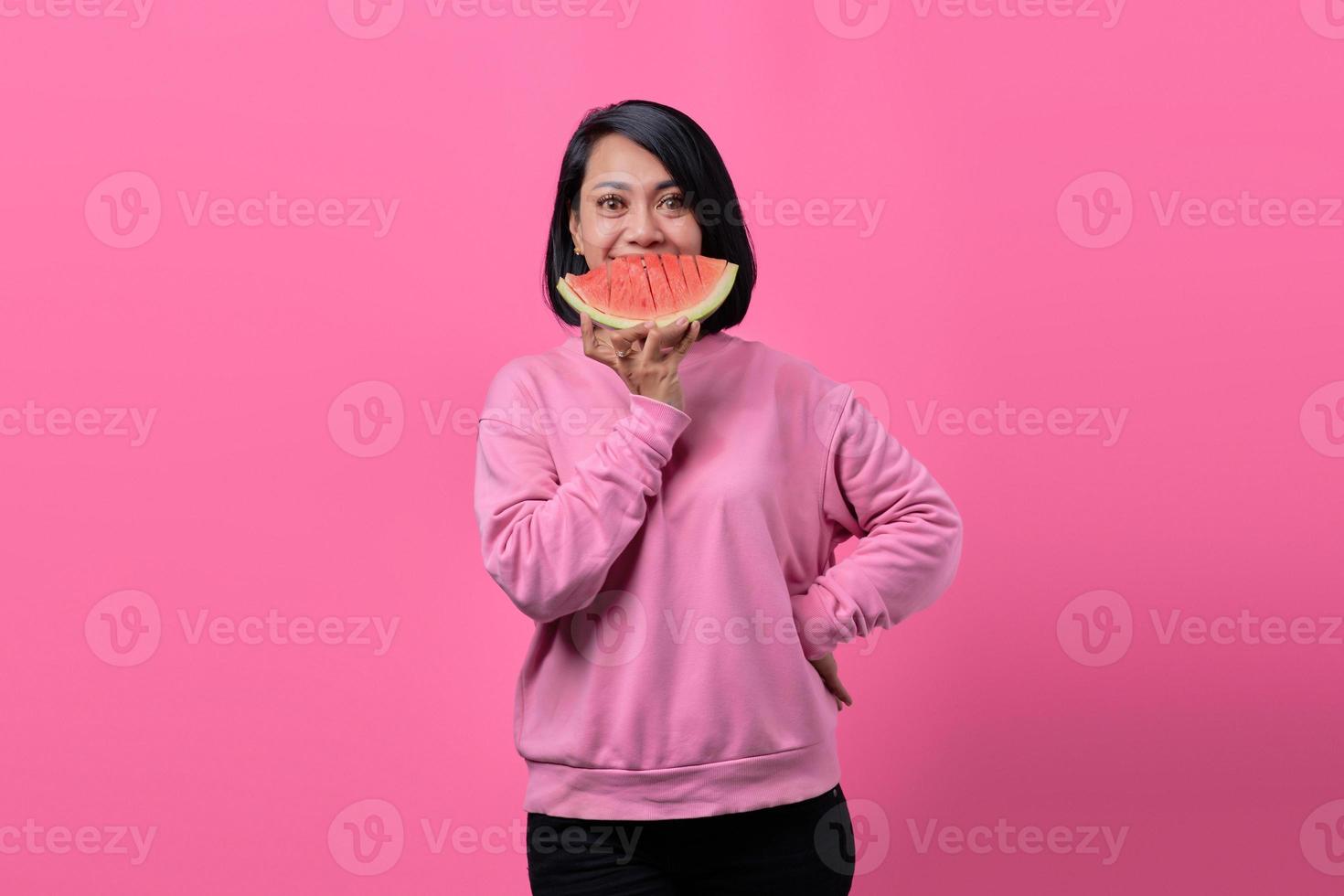 Attractive young Asian woman holding watermelon pieces photo