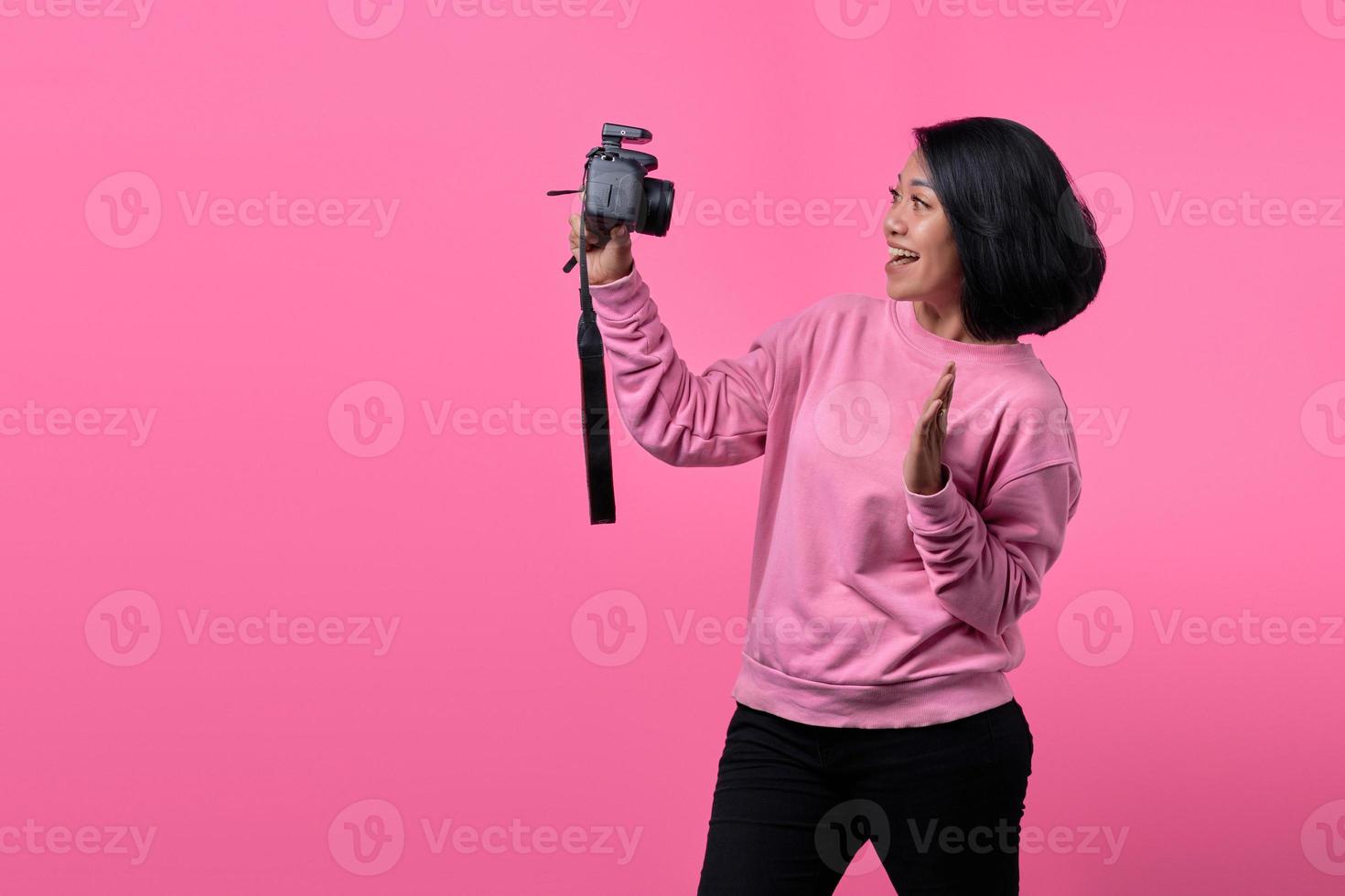 Beautiful girl taking a self portrait with professional camera. photo