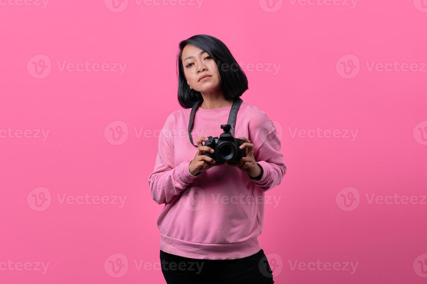 mujer joven sosteniendo la cámara con expresión plana foto