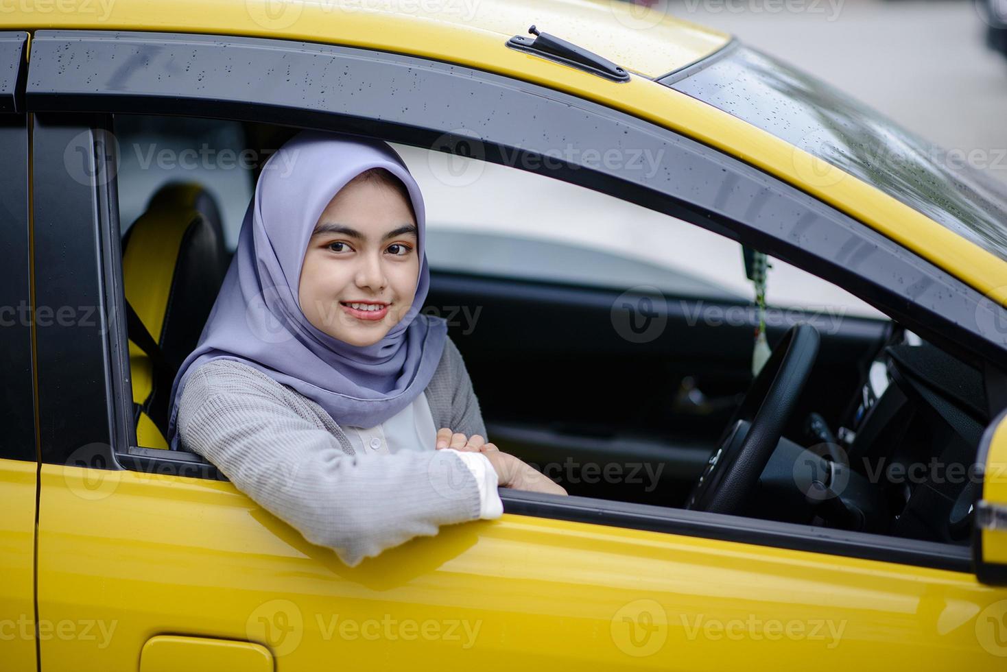 Portrait of smiling Asian Muslim woman in car photo