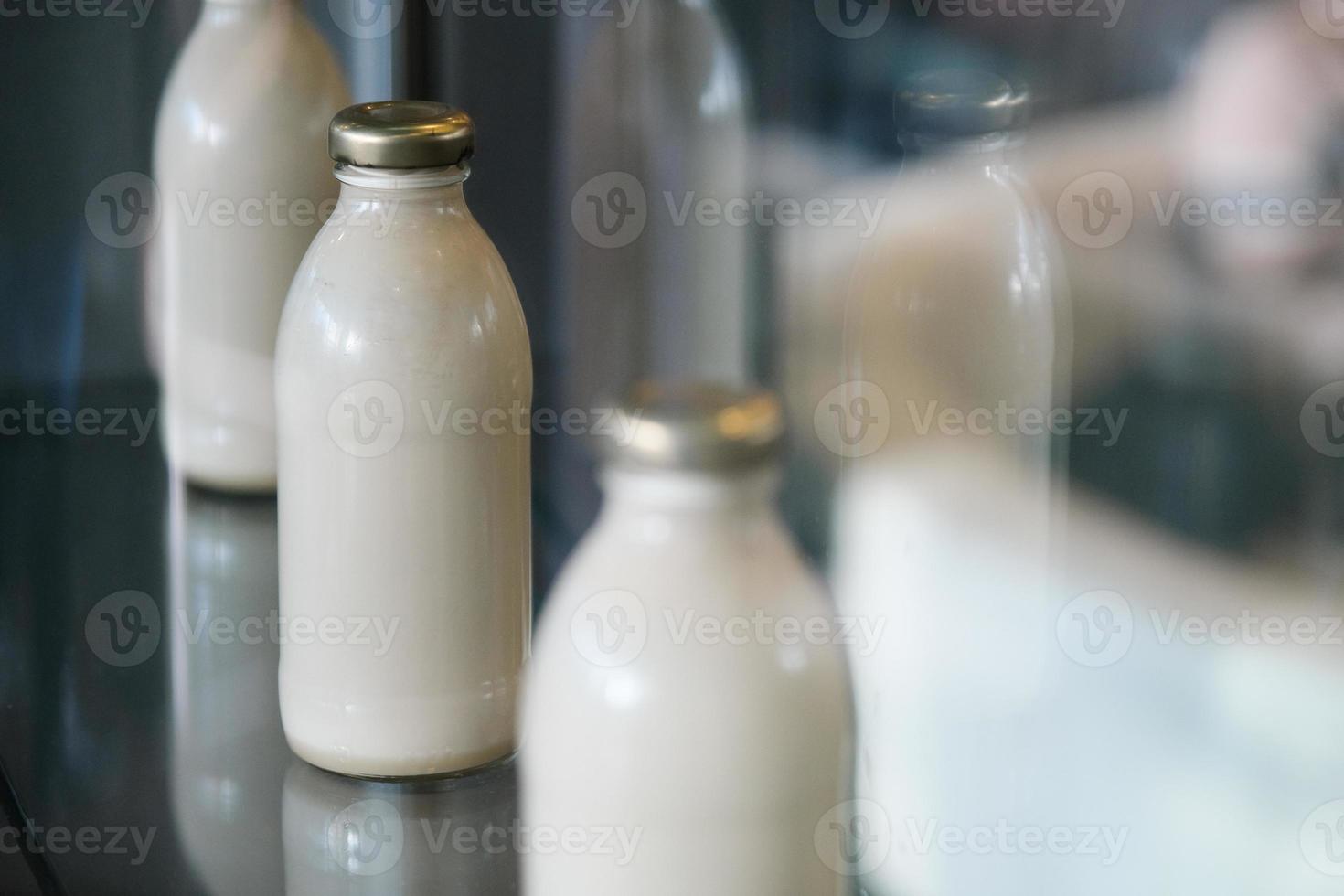 Botellas de leche blanca retro colocadas en el escaparate de la tienda orgánica como decoración foto