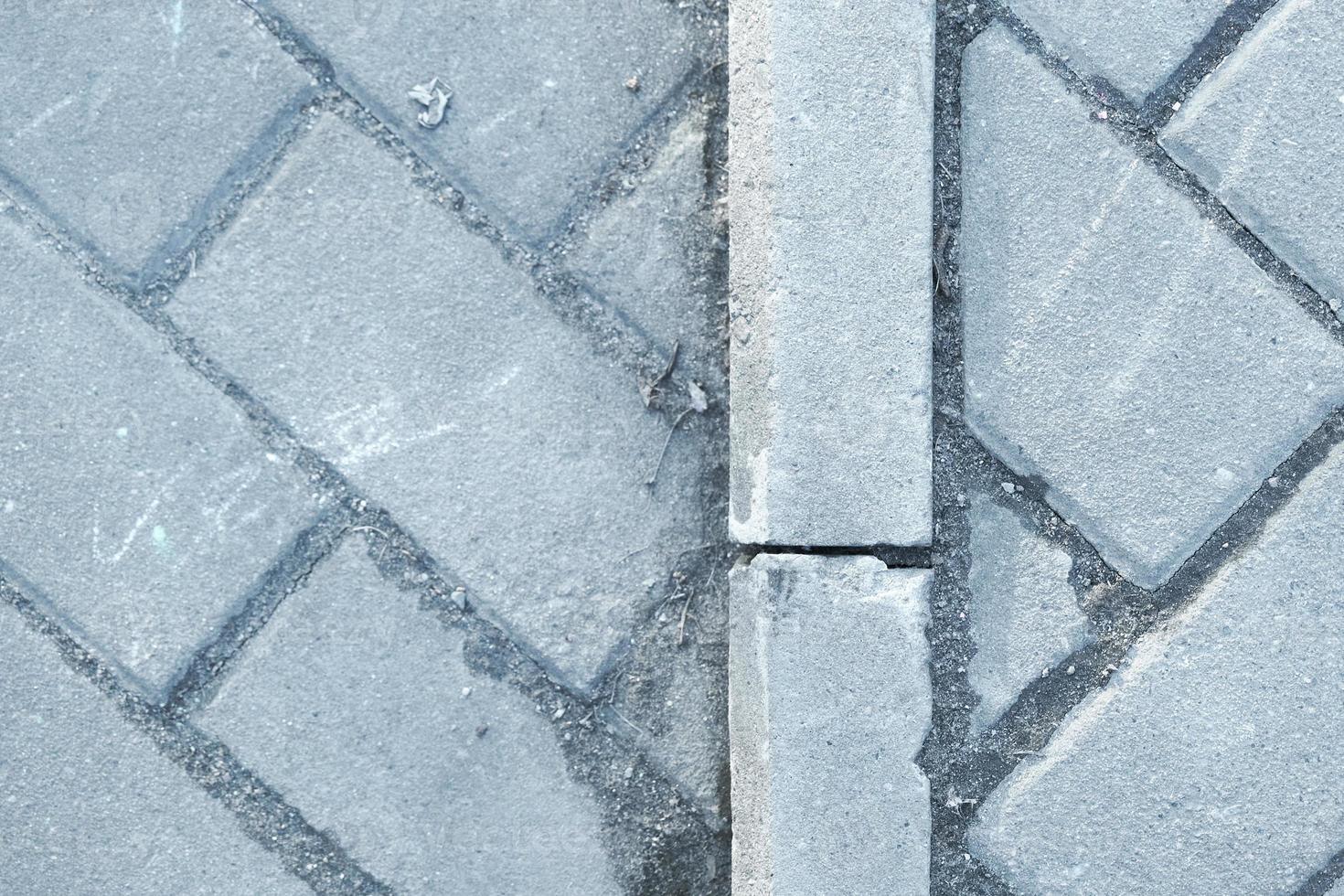 Pavement pattern made of rectangular blocks of grey stone bricks photo