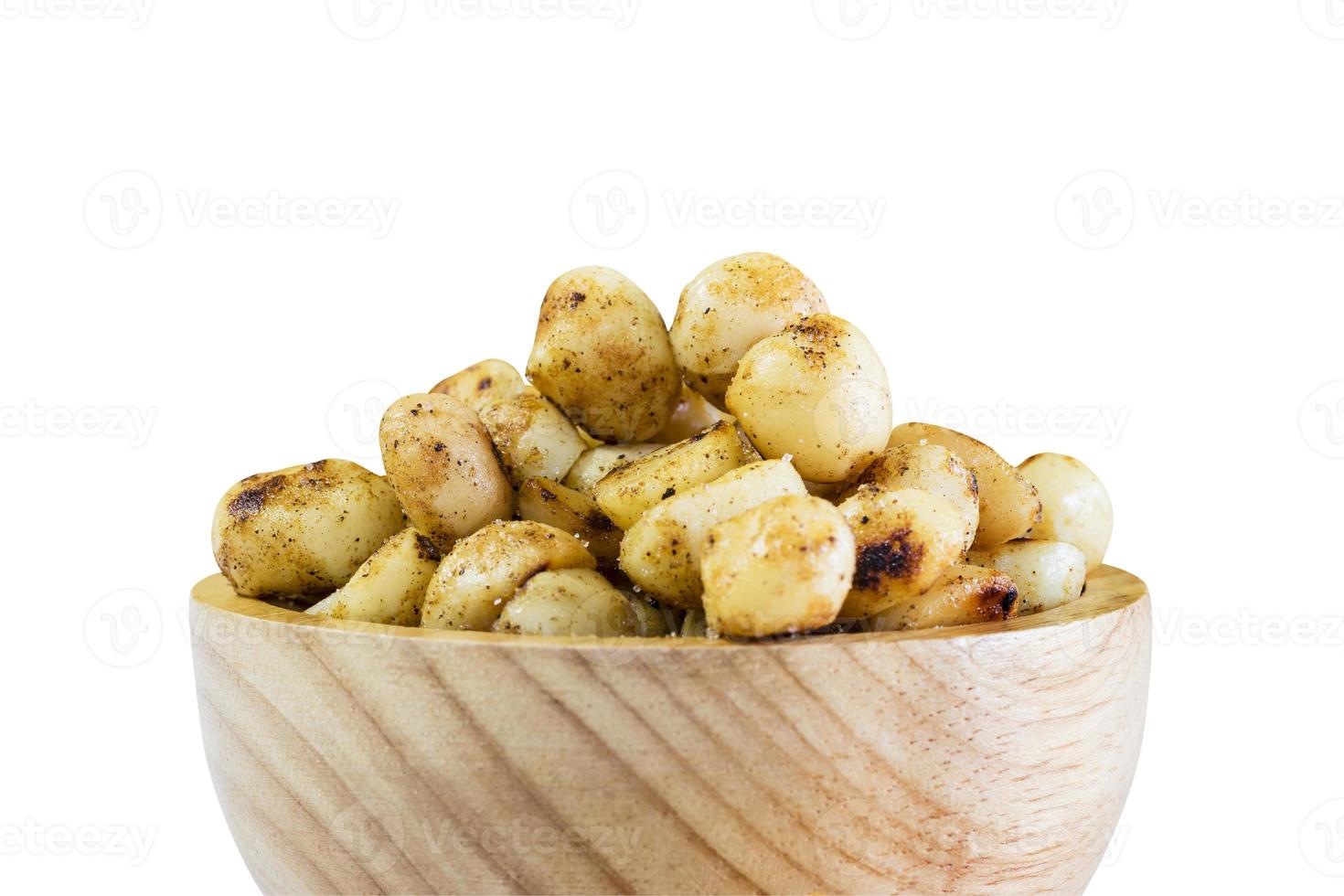 Macadamia baked with salted in wooden bowl on white with path photo