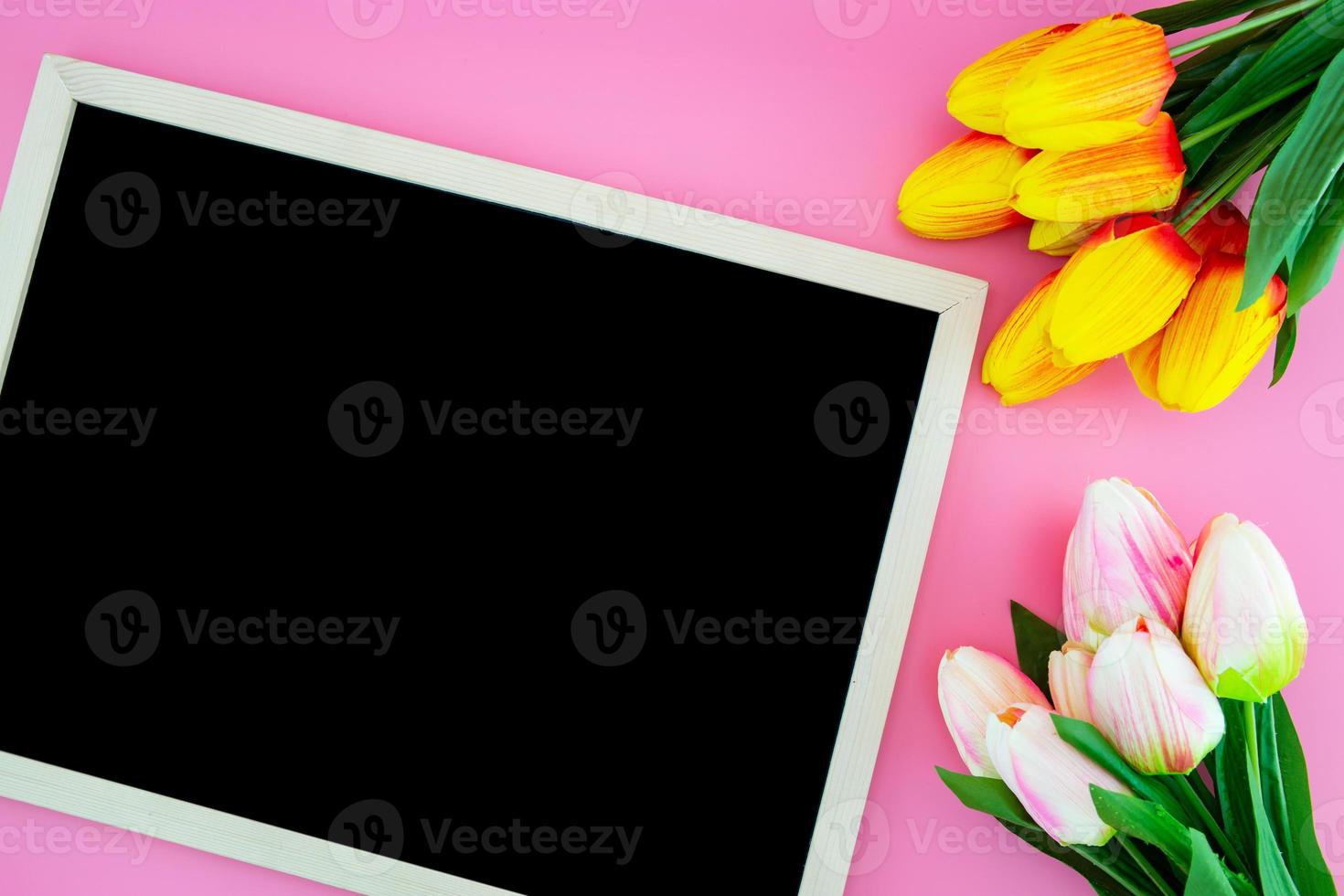 Tulip flower and chalkboard, blackboard with flat lay on the pink. photo