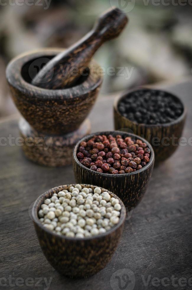 Organic white red and black pepper corns in wood display photo