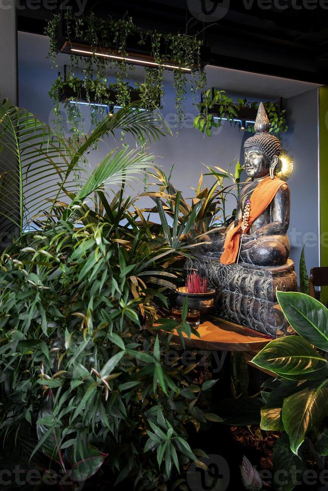 buddha statue in interior garden at tropical bar in thailand photo