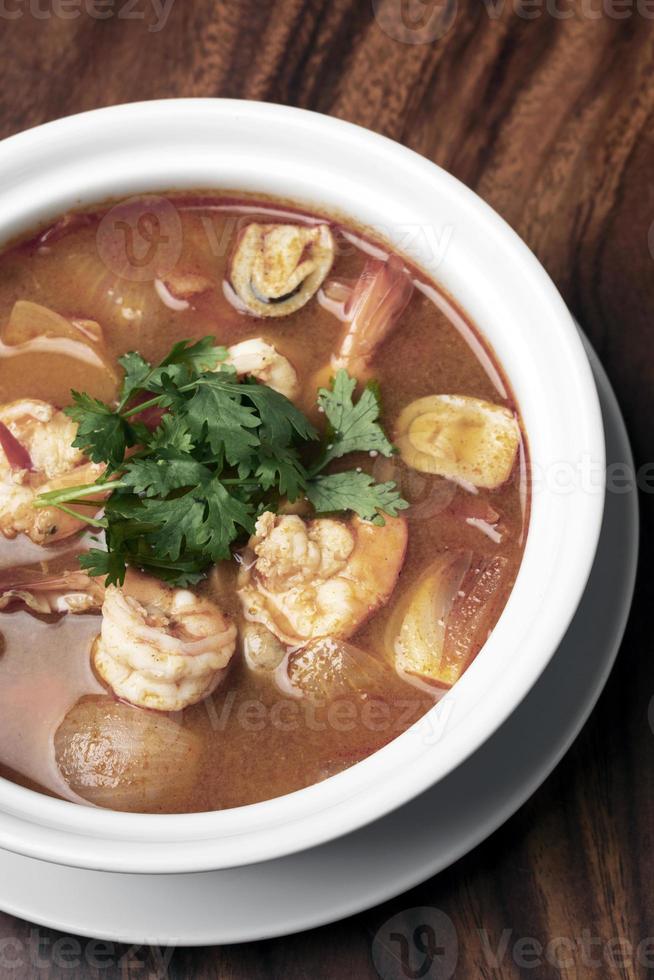 Thai tom yum kung sopa de camarones agria y picante en el fondo de la tabla de madera en phuket, tailandia foto