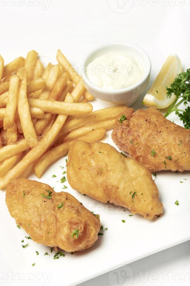 Comida tradicional británica de pescado y patatas fritas en la placa blanca. foto