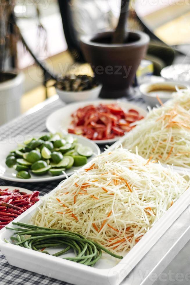 Thai Som Tam papaya salad ingredients at catering buffet preparation table station in Thailand photo