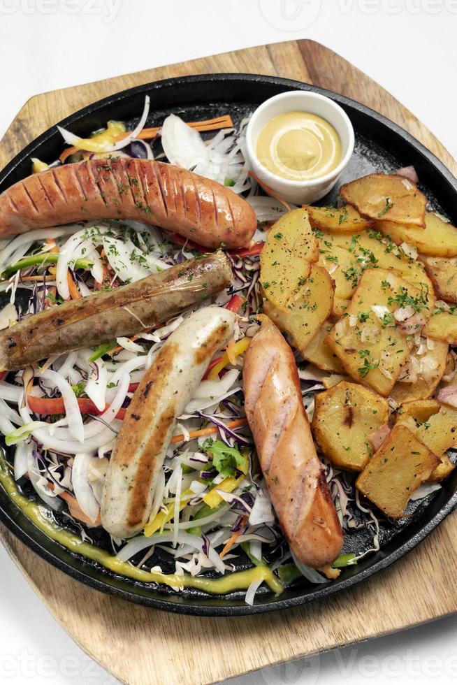 Mixed german traditional organic sausage and potato meal platter including Nurnberger, Lamb and Pork with salad and mustard photo