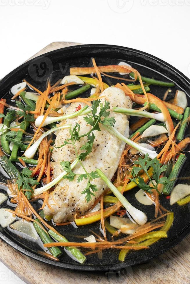 Chinese Cantonese style steamed spicy fish fillet with vegetables on hot plate photo