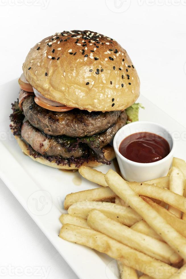 Hamburguesa de ternera orgánica australiana con plato de papas fritas sobre fondo blanco studio foto