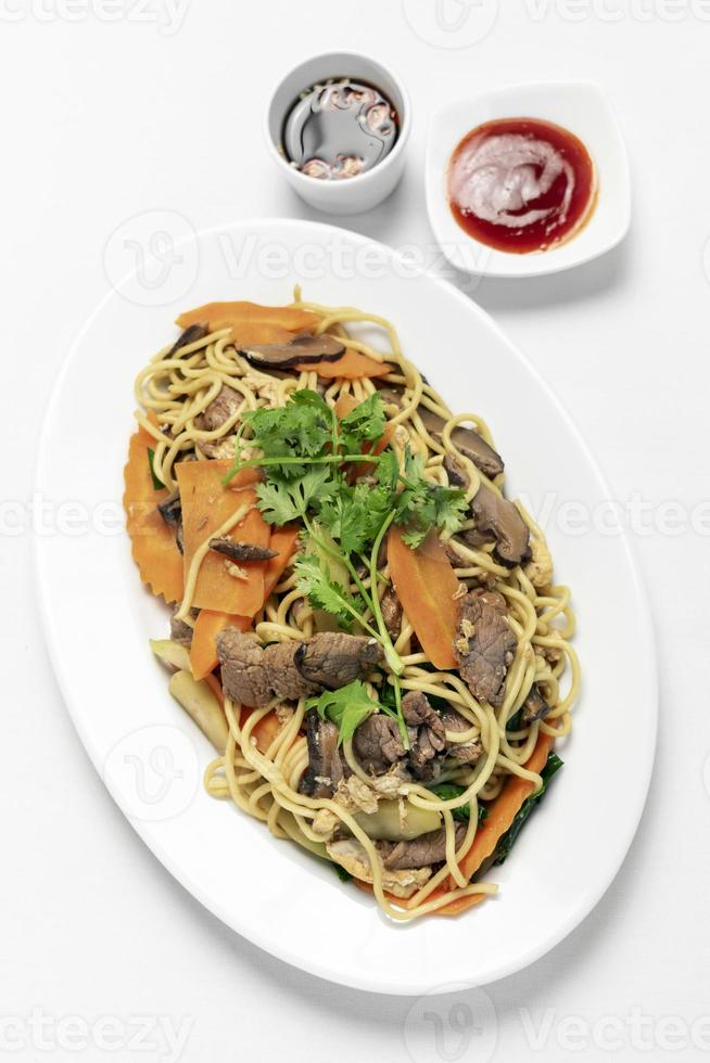 Traditional Khmer spicy beef stir fry with egg noodles and vegetables in Cambodia on white studio background photo