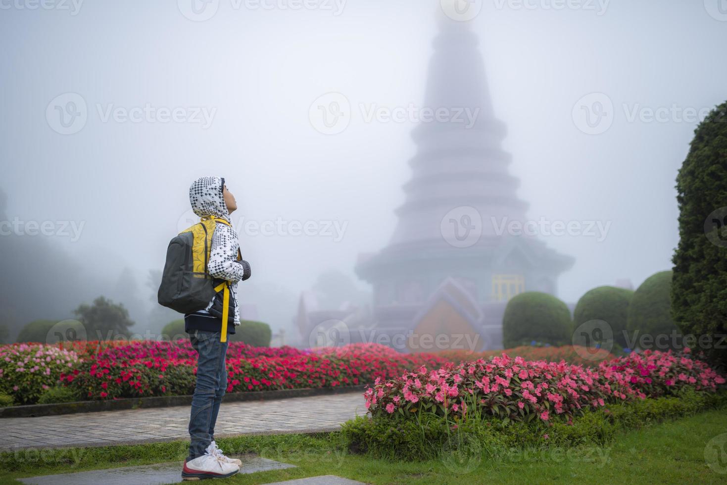 Young traveler boy with bag in beautiful fog garden photo