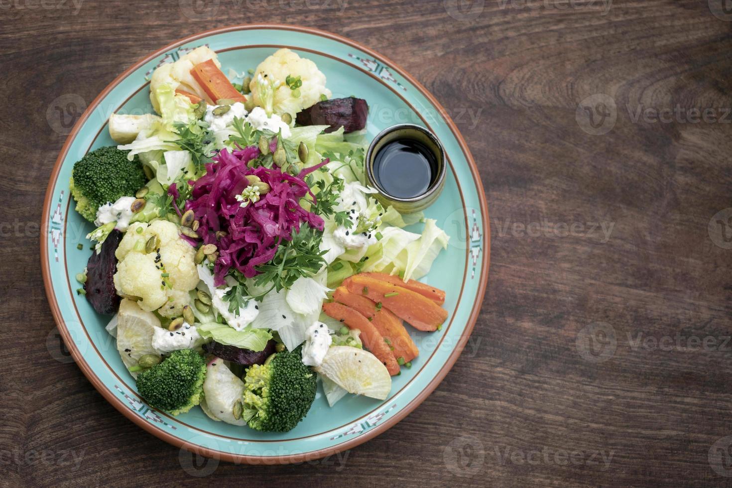 Rustic cottage salad with healthy mixed steamed and fresh vegetables on colorful plate outdoors in garden photo