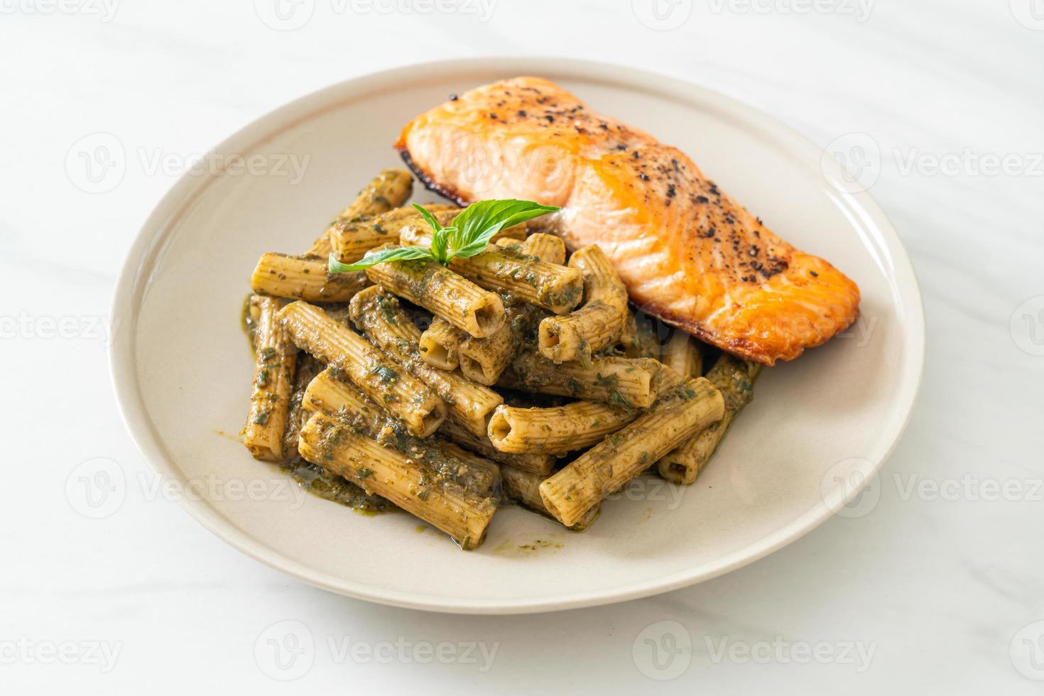 Pesto quadrotto penne pasta with grilled salmon fillet steak photo