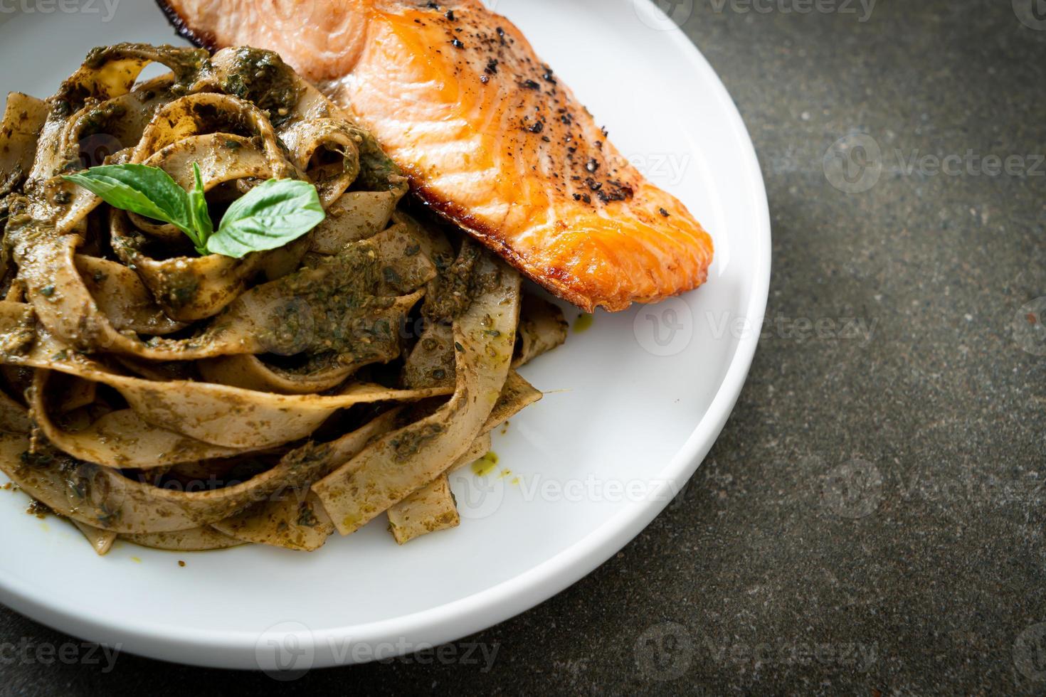 Pasta de espaguetis fettuccine al pesto casero con filete de salmón a la parrilla foto